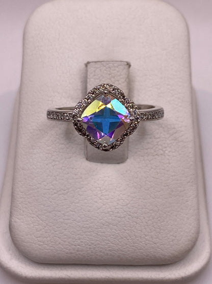 Anillo solitario de plata con circonia Aurora multicolor en almohada blanca