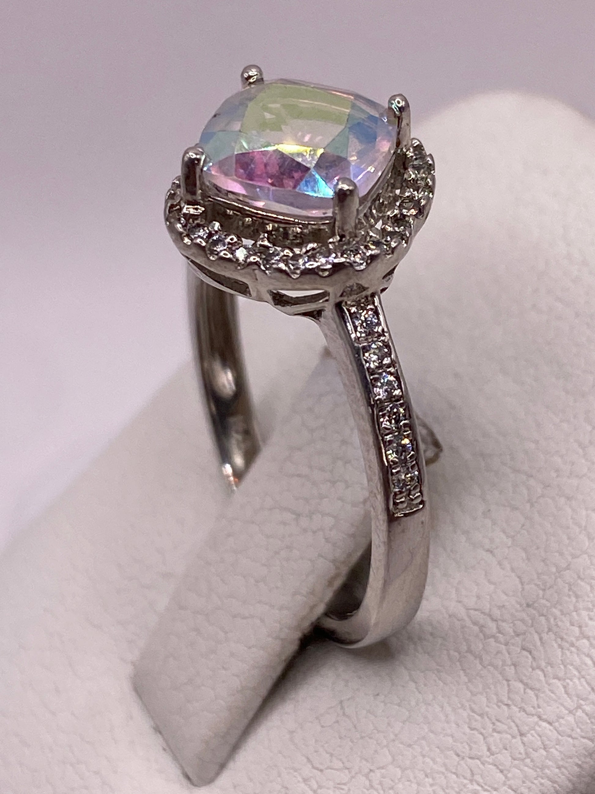 Anillo solitario en dedo con circonia reflejando colores arcoíris