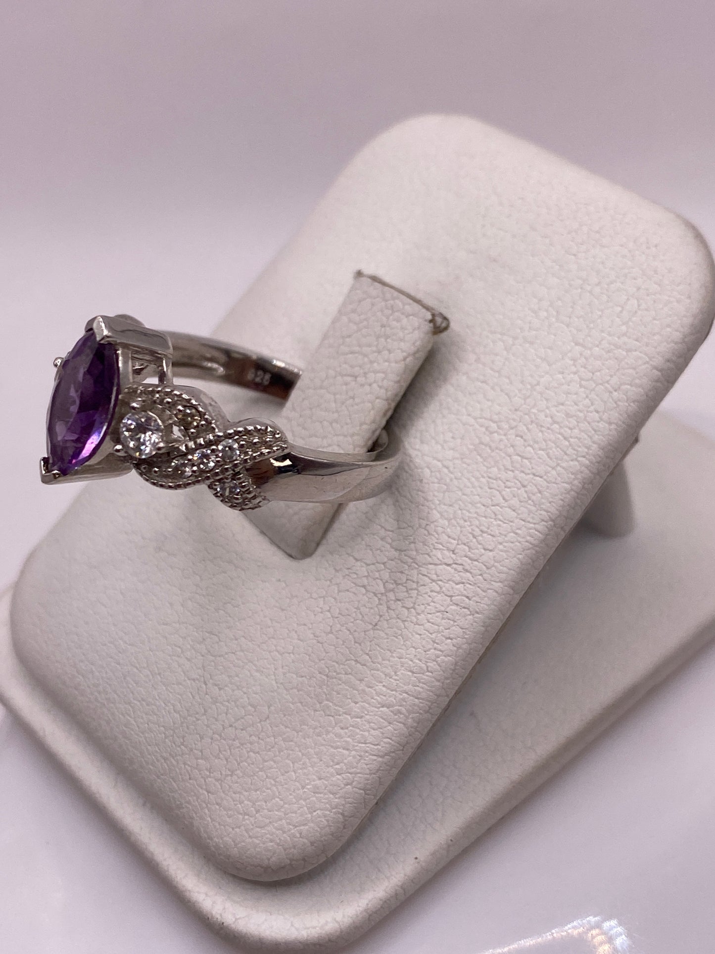 Vista frontal del anillo morado con alas en relieve, luz cenital