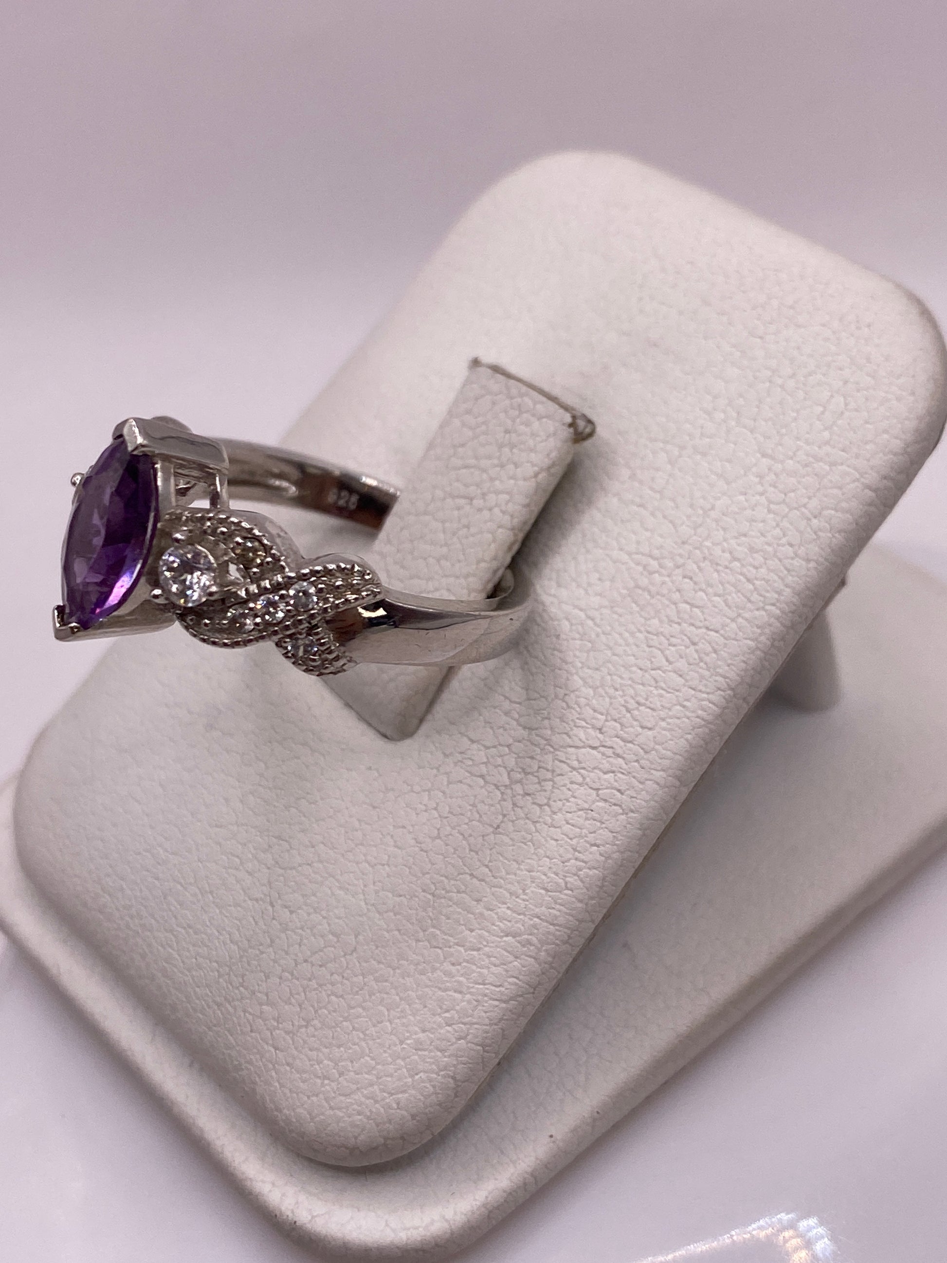 Vista frontal del anillo morado con alas en relieve, luz cenital