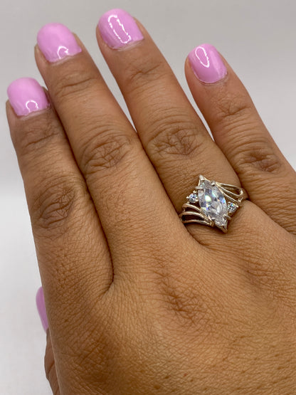 Anillo solitario en dedo de mujer con uñas rosadas, mostrando el brillo natural