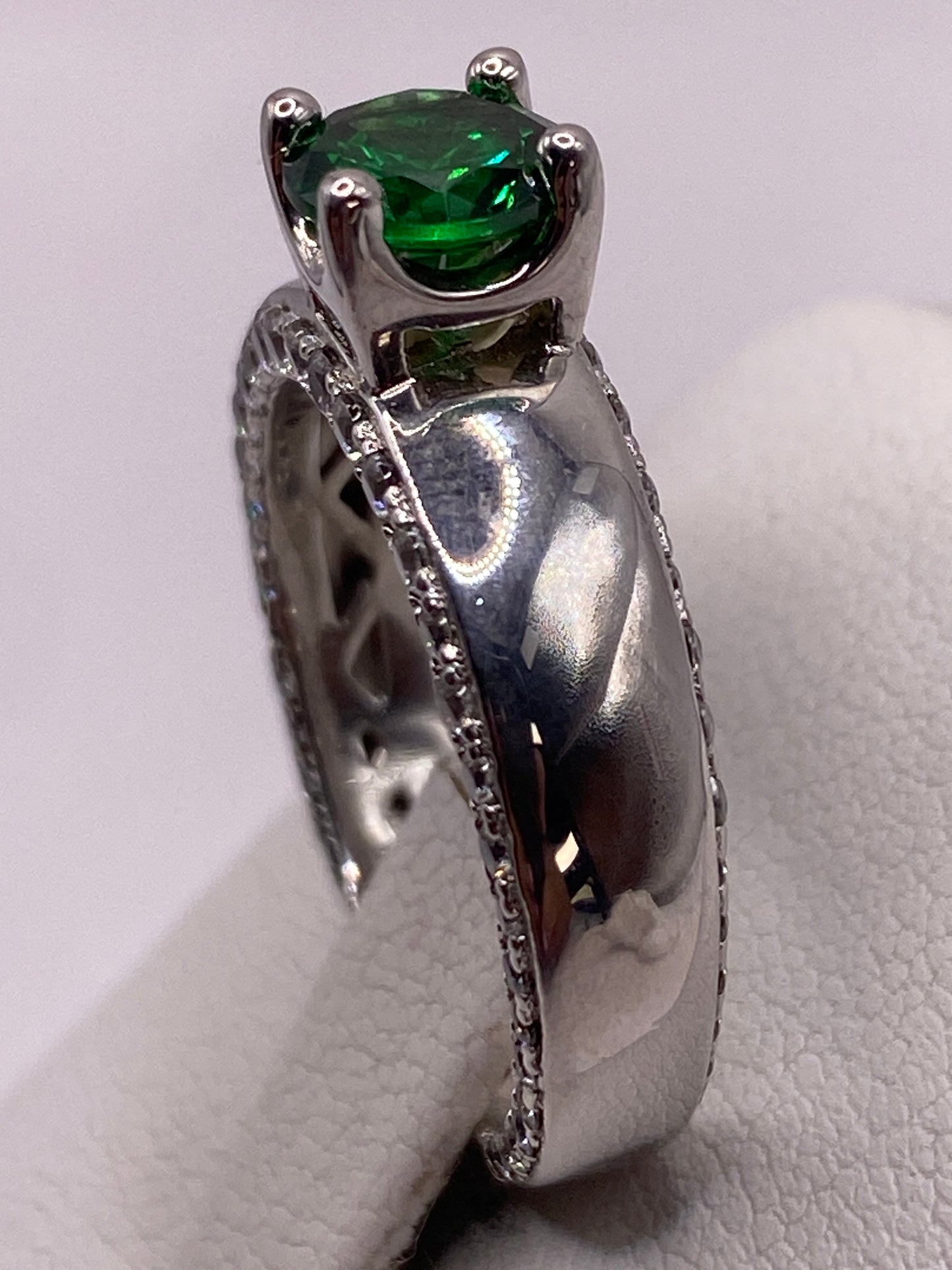 Anillo solitario sobre mano mostrando el brillo de la circonia verde