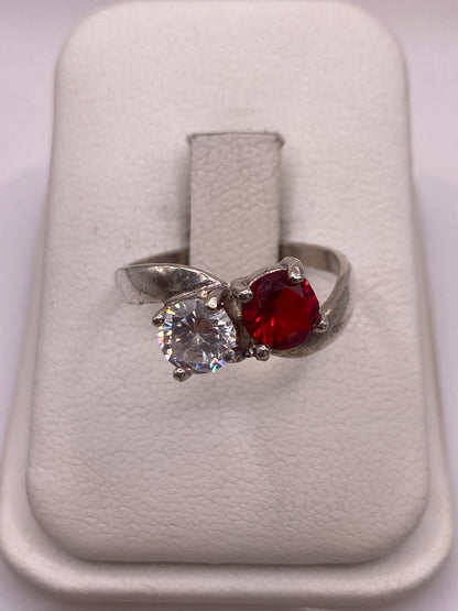 Anillo de plata con dos circonias roja y blanca brillantes en la mano de una mujer
