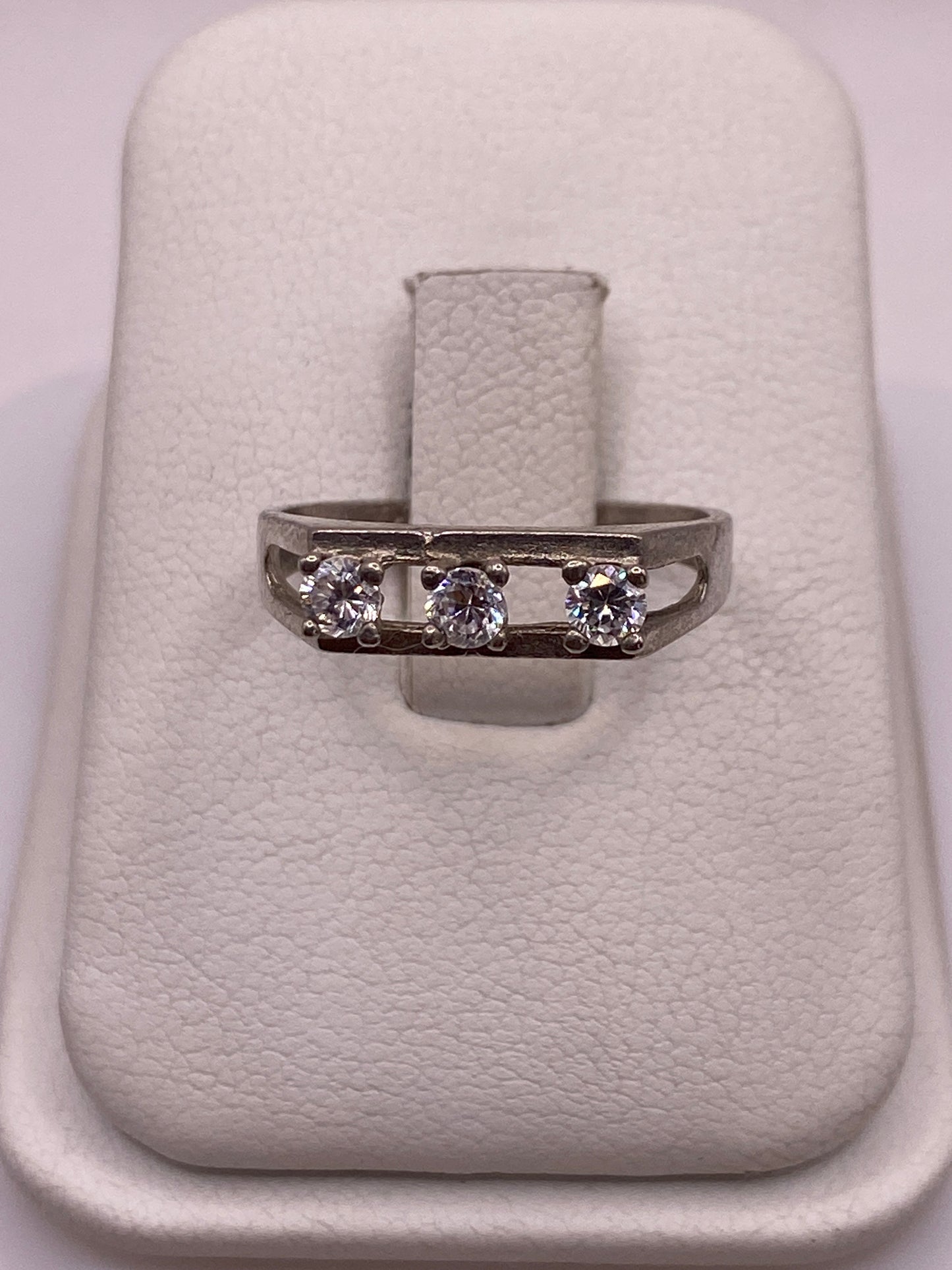 Anillo de plata solitario con circonia blanca en la mano de una mujer