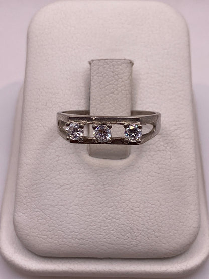 Anillo de plata solitario con circonia blanca en la mano de una mujer