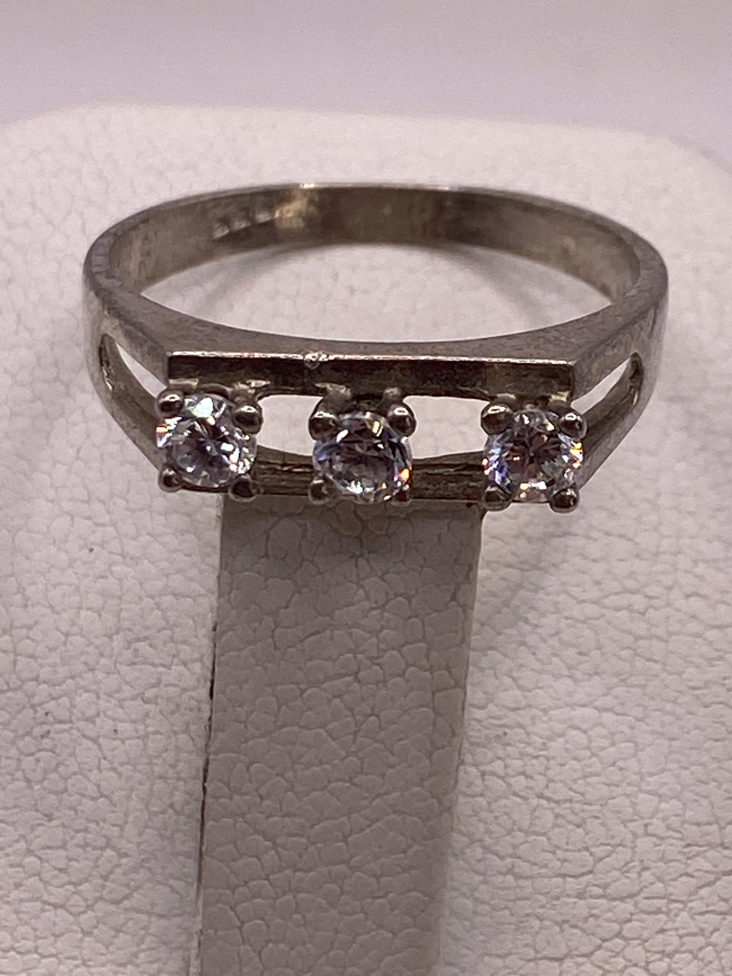 Anillo solitario de banda abierta fotografiado de frente en estuche de presentación