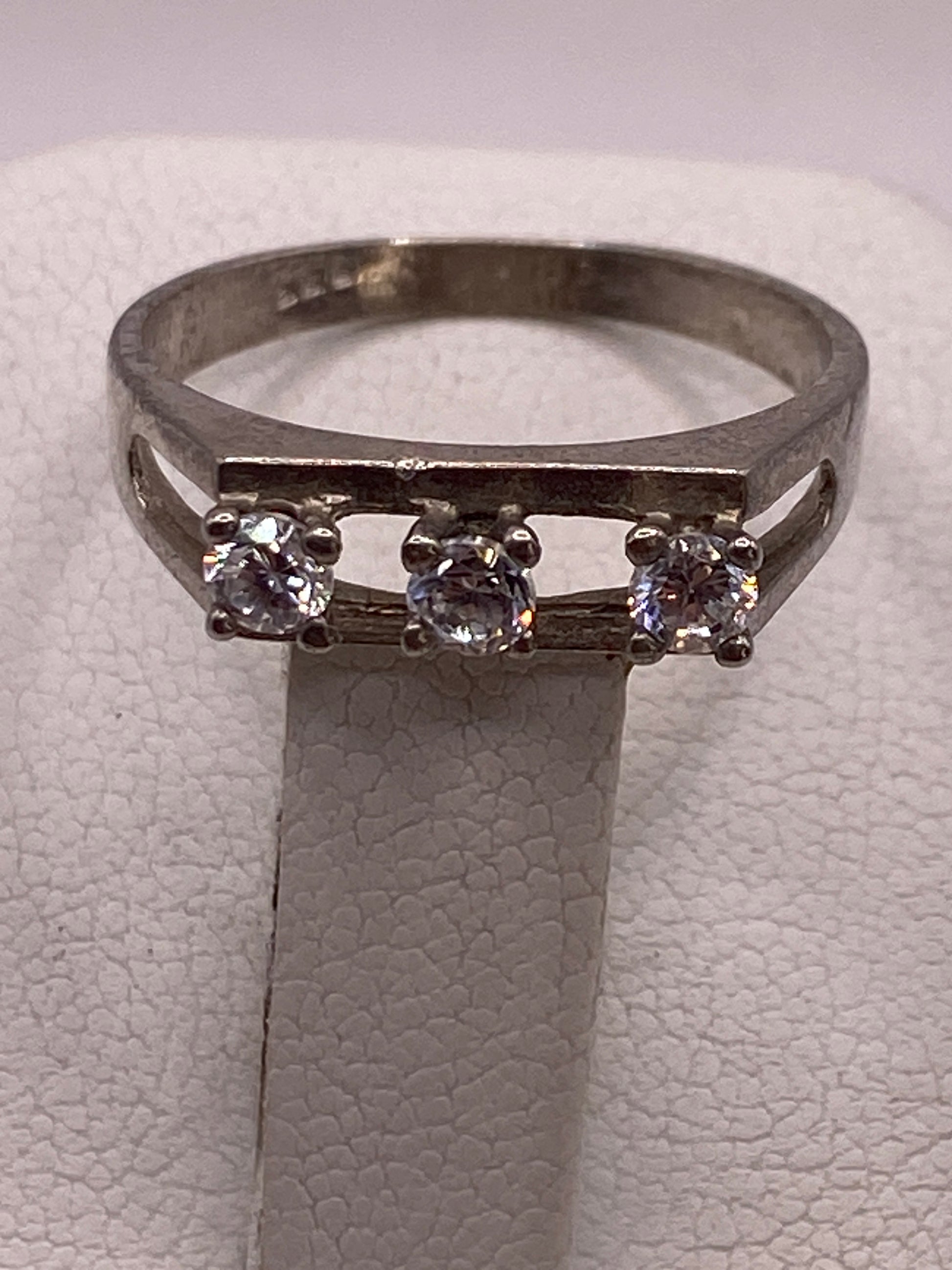 Anillo solitario de banda abierta fotografiado de frente en estuche de presentación