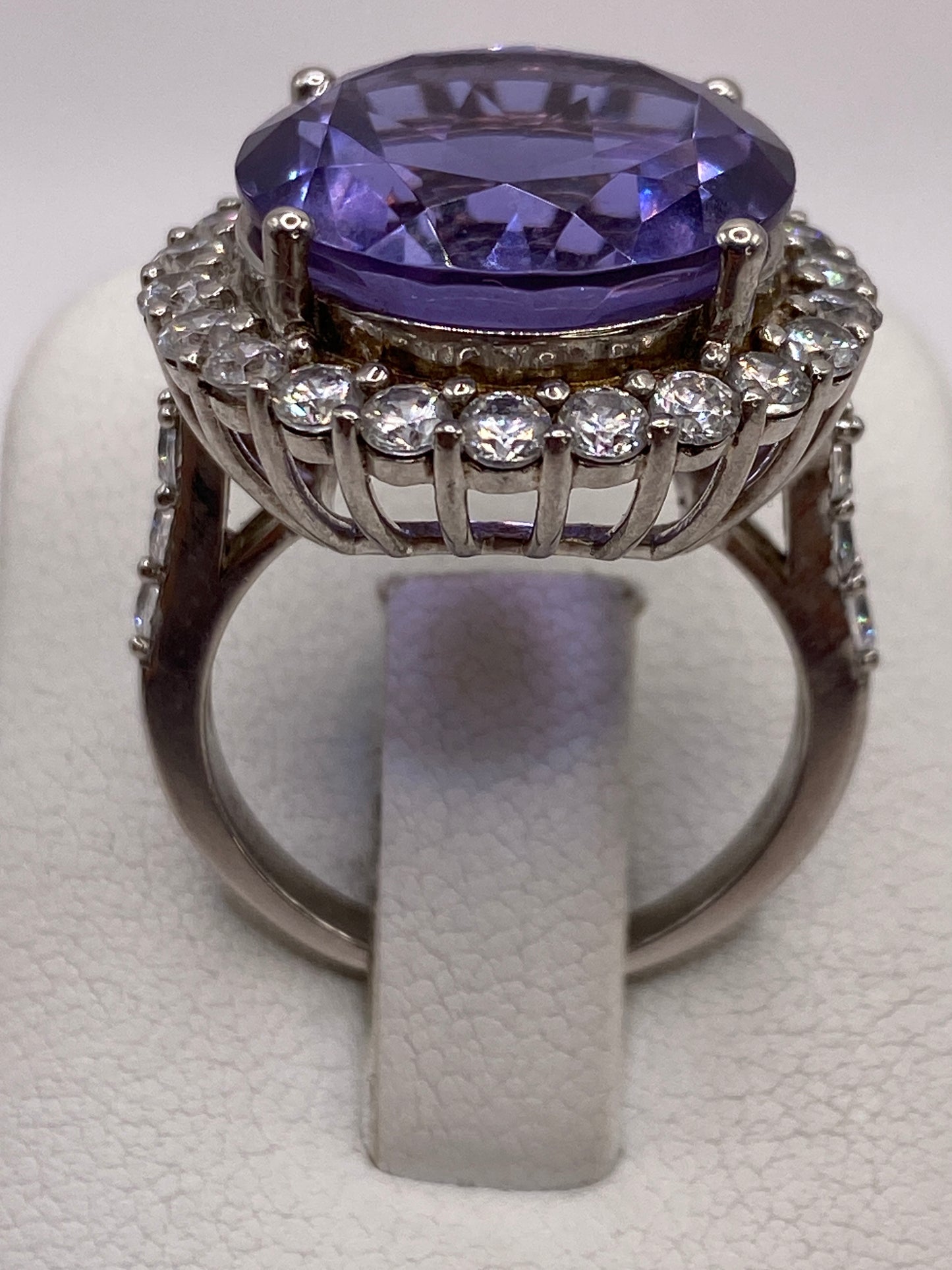 Anillo de plata solitario con circonia morada ovalada, vista superior sobre fondo blanco