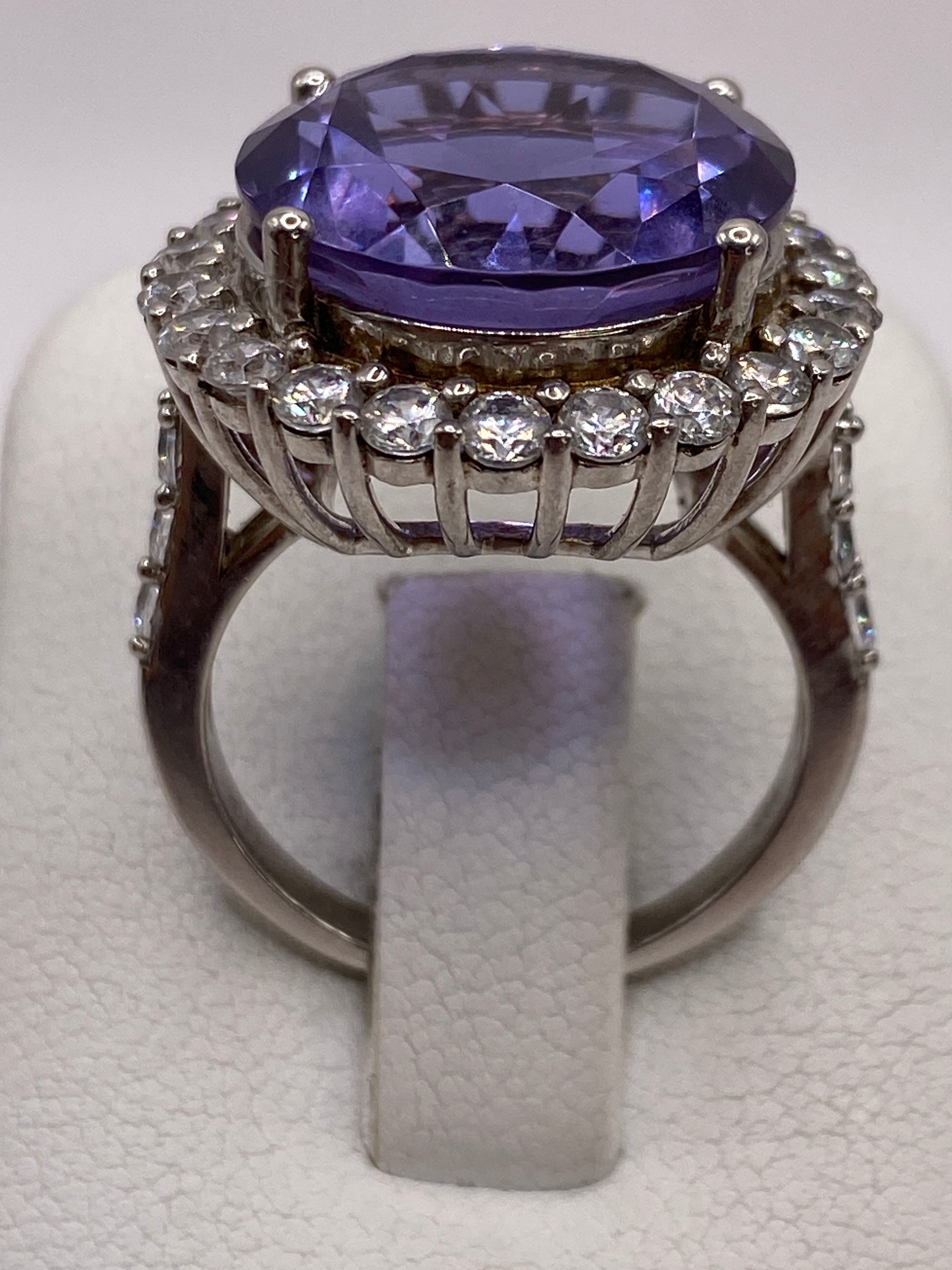 Anillo de plata solitario con circonia morada ovalada, vista superior sobre fondo blanco