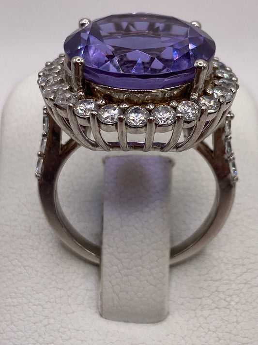 Anillo de plata solitario con circonia morada ovalada, vista superior sobre fondo blanco