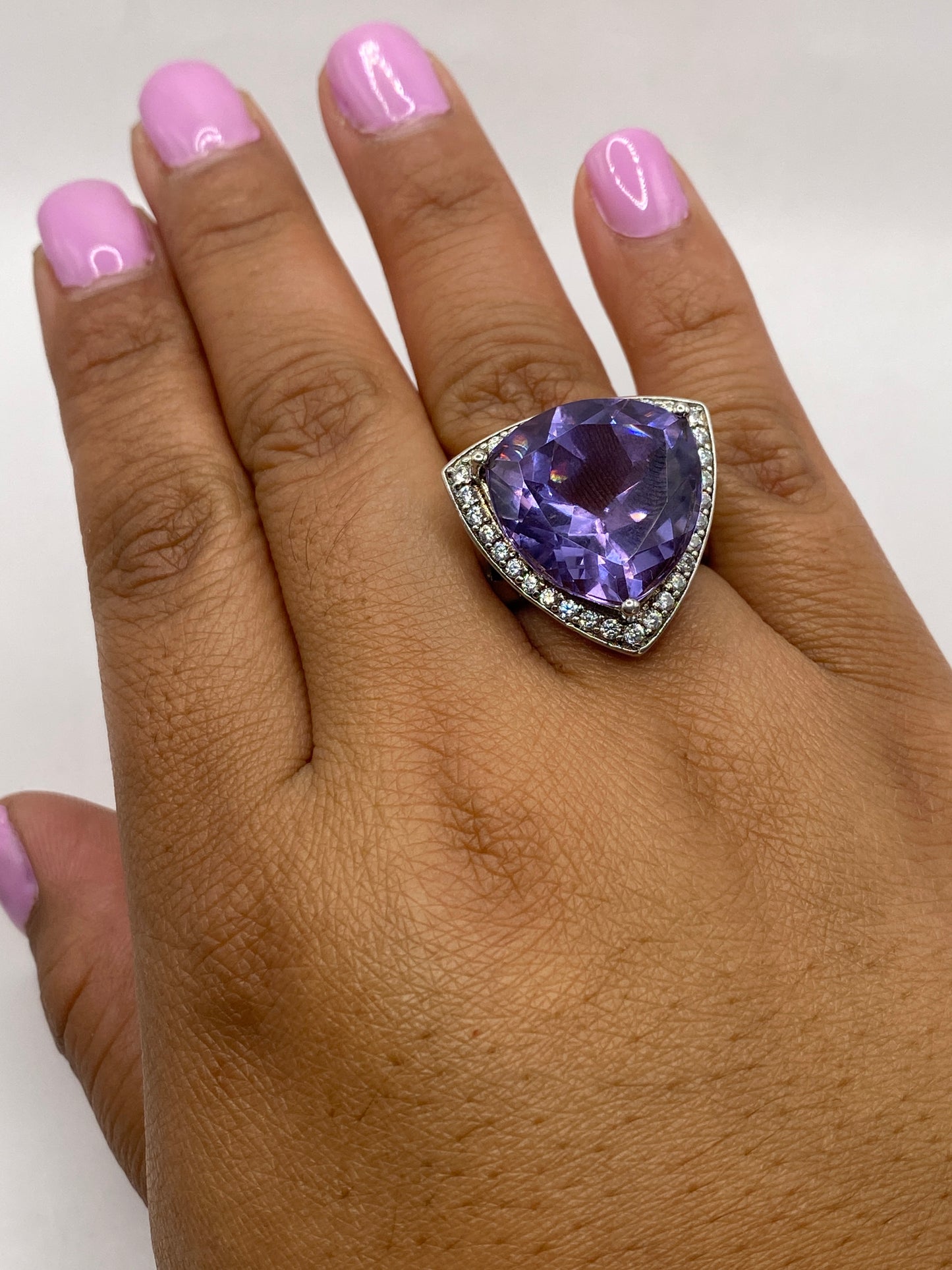 Anillo en dedo mostrando el brillo y fuego de la circonia morada