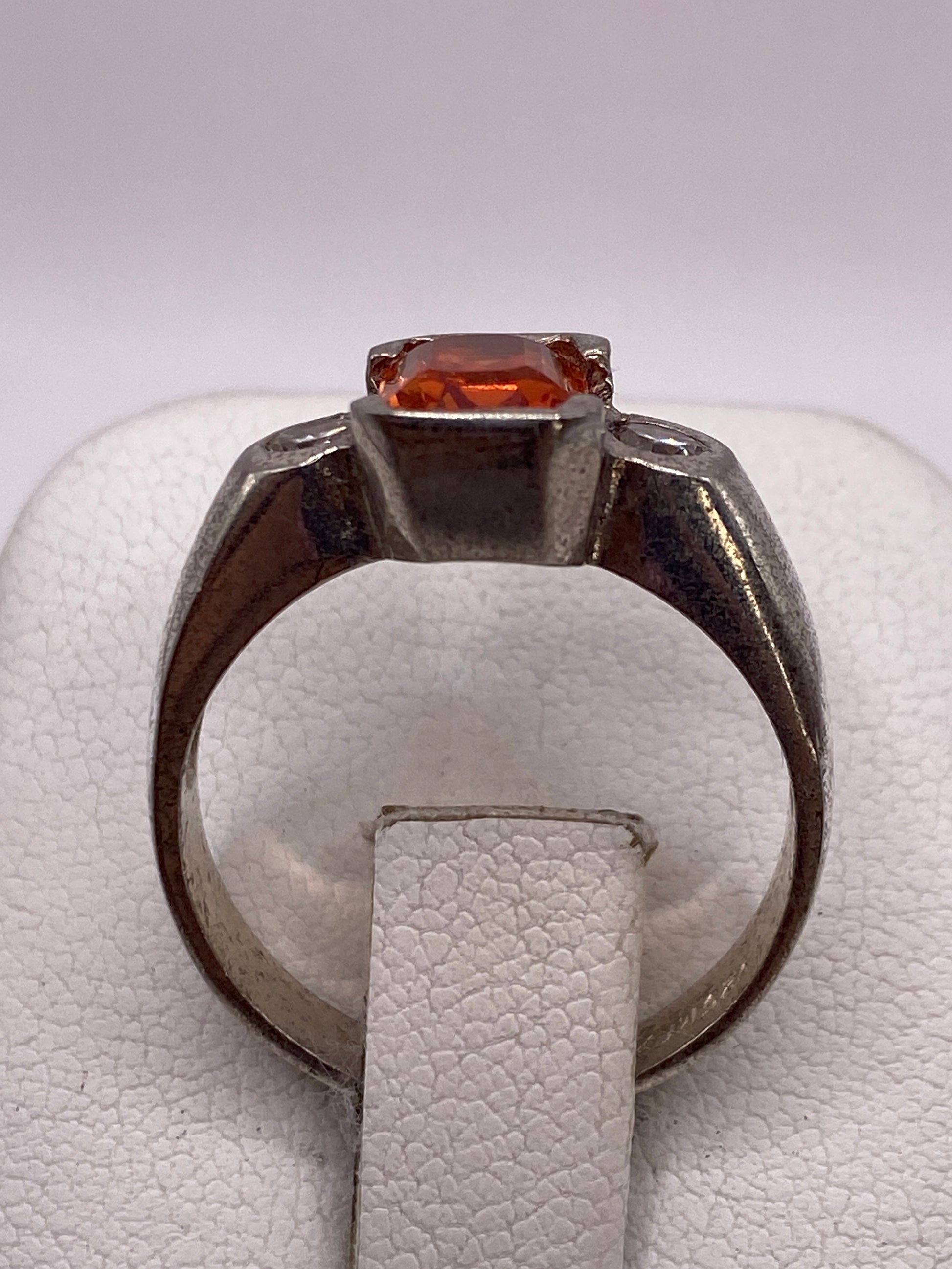 Vista frontal del anillo de plata .925 con piedra naranja facetada