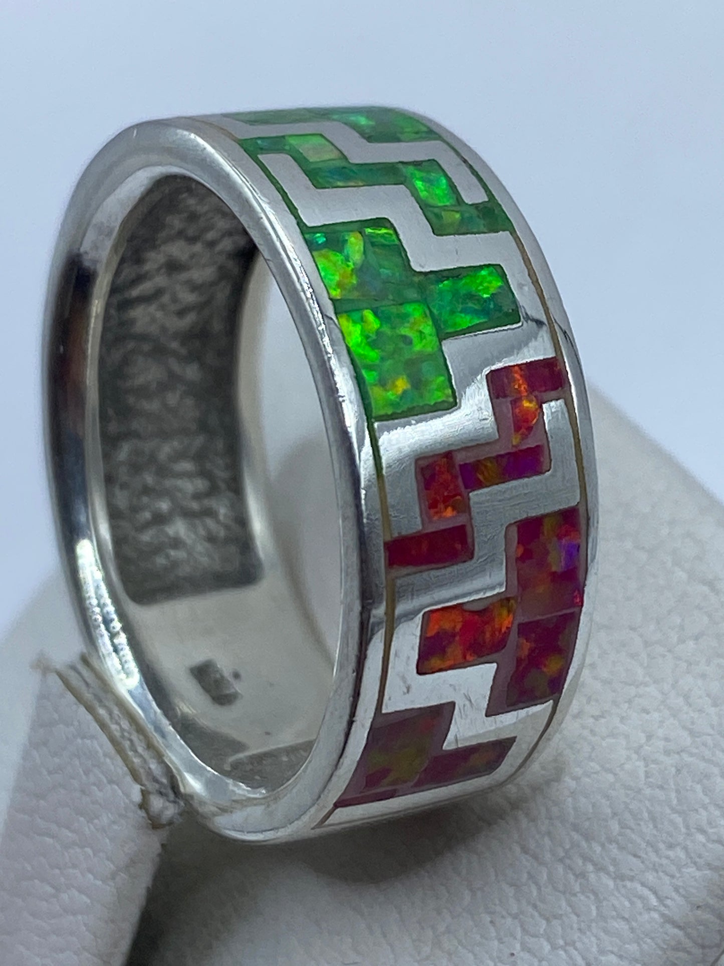 Anillo ópalo de fuego puesto en mano de mujer, reflejando los colores naturales de la piedra