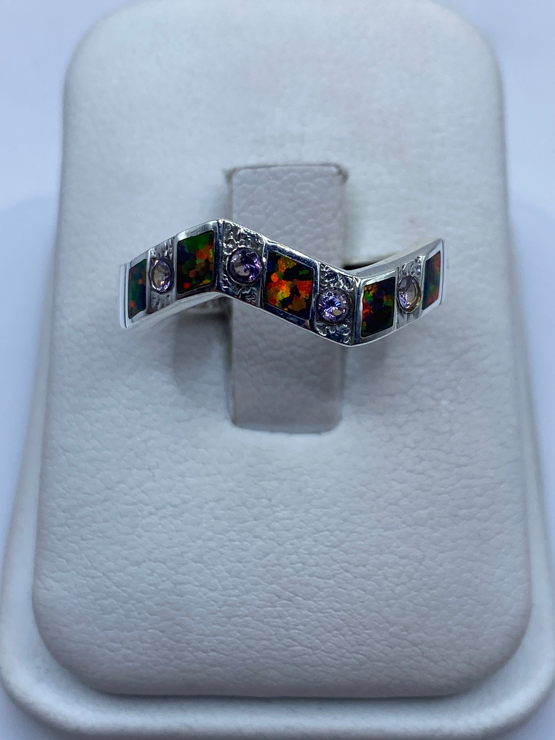 Anillo de plata .950 con ópalo de fuego multicolor en forma geométrica sobre presentador blanco
