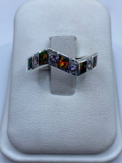 Anillo de plata .950 con ópalo de fuego multicolor en forma geométrica sobre presentador blanco