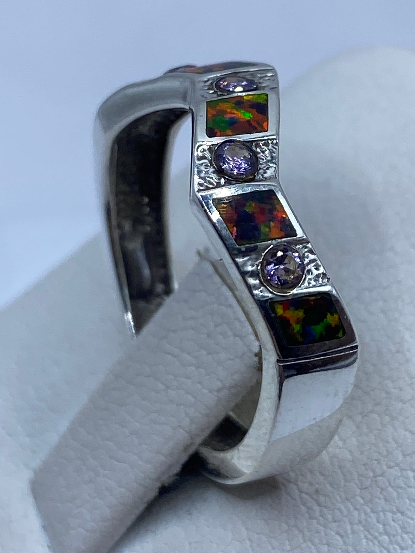 Anillo geométrico de plata .950 en la mano mostrando el brillo espejo y juego de luz del ópalo