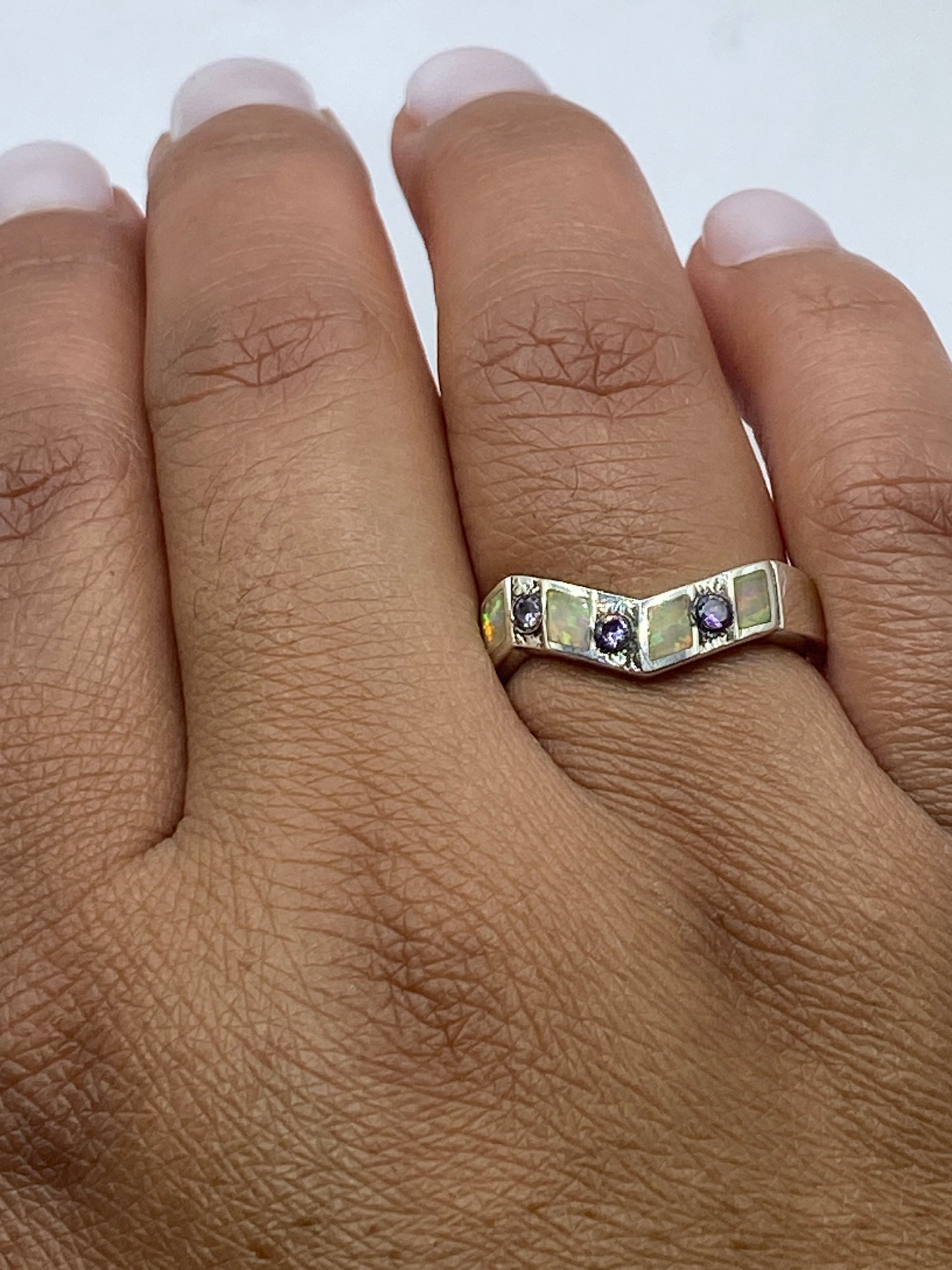 Anillo en la mano mostrando cómo el ópalo brilla con luz natural