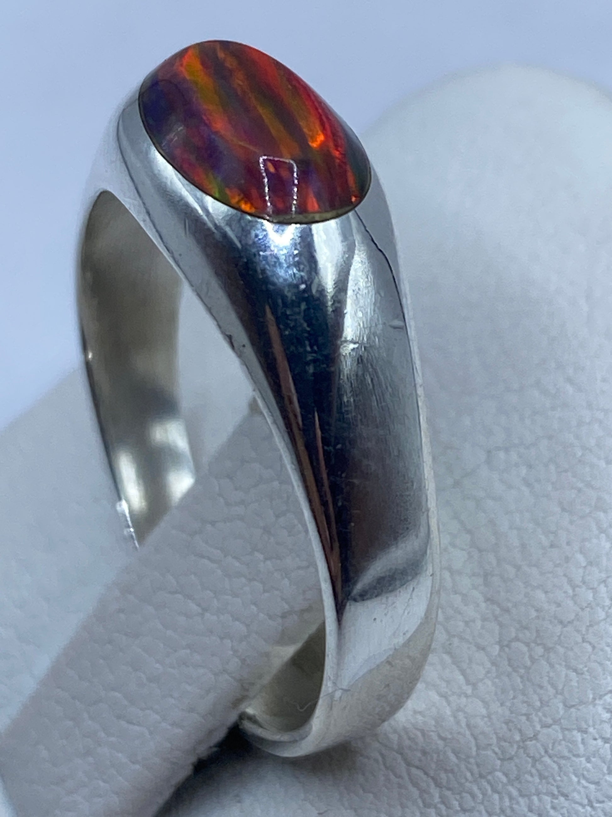 Anillo sobre dedo de mujer luciendo el juego de colores del Ópal