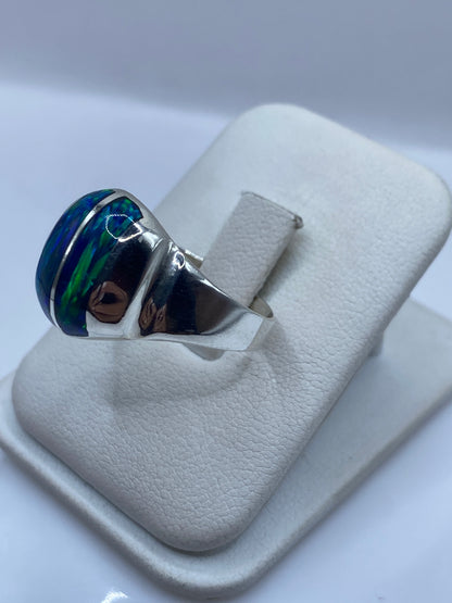Detalle frontal del ópalo de fuego con juego de color azul en anillo de plata pura