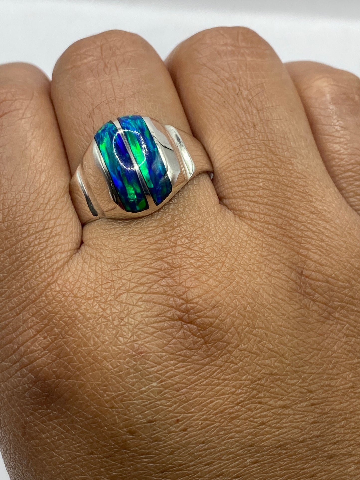 Anillo en dedo de hombre mostrando el cambio de color azul verde del ópalo de fuego