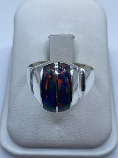 Anillo escultural de plata .950 con ópalo de fuego multicolor, vista frontal en estuche blanco