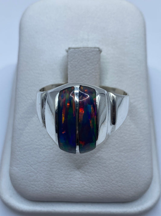 Anillo escultural de plata .950 con ópalo de fuego multicolor, vista frontal en estuche blanco