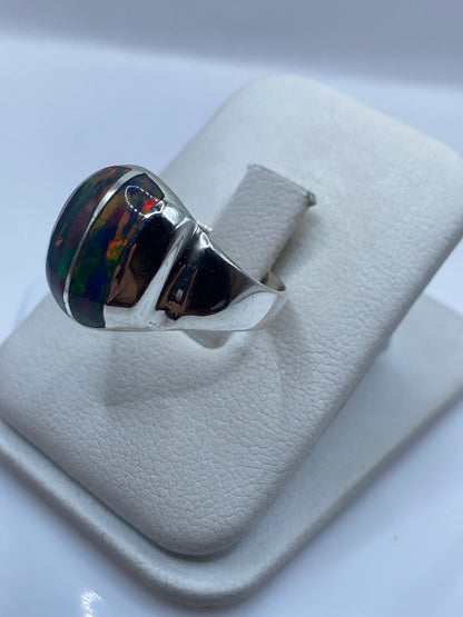 Detalle lateral del anillo mostrando el juego de colores rojo, azul y verde del ópalo de fuego