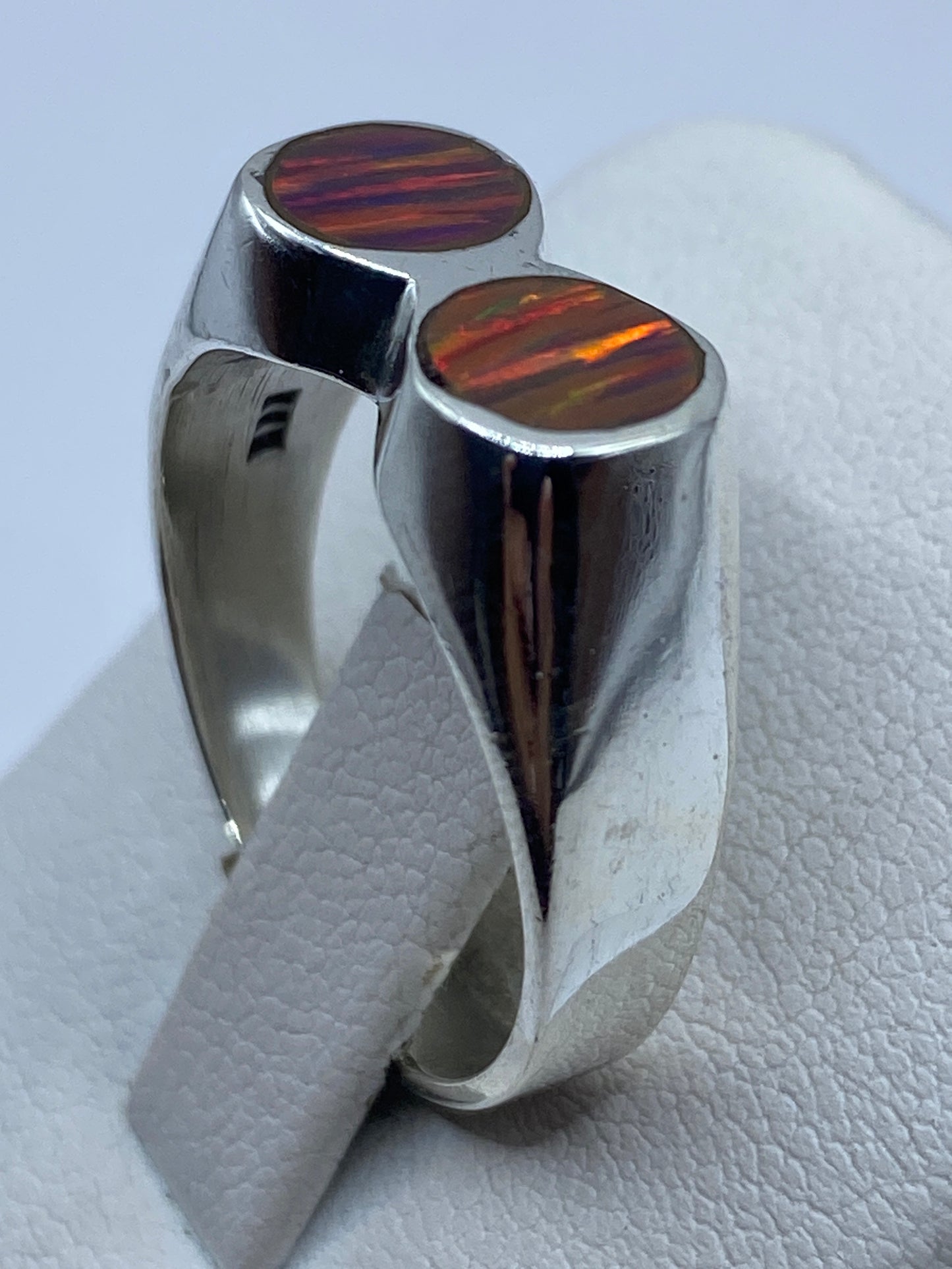 Anillo solitario ópalo de fuego en dedo mostrando la banda de 8 mm de plata .950