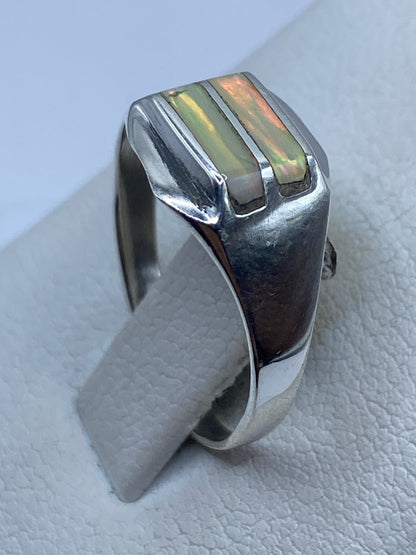 Vista lateral del anillo de plata con ópalo natural, mostrando el engaste limpio y el pulido brillante