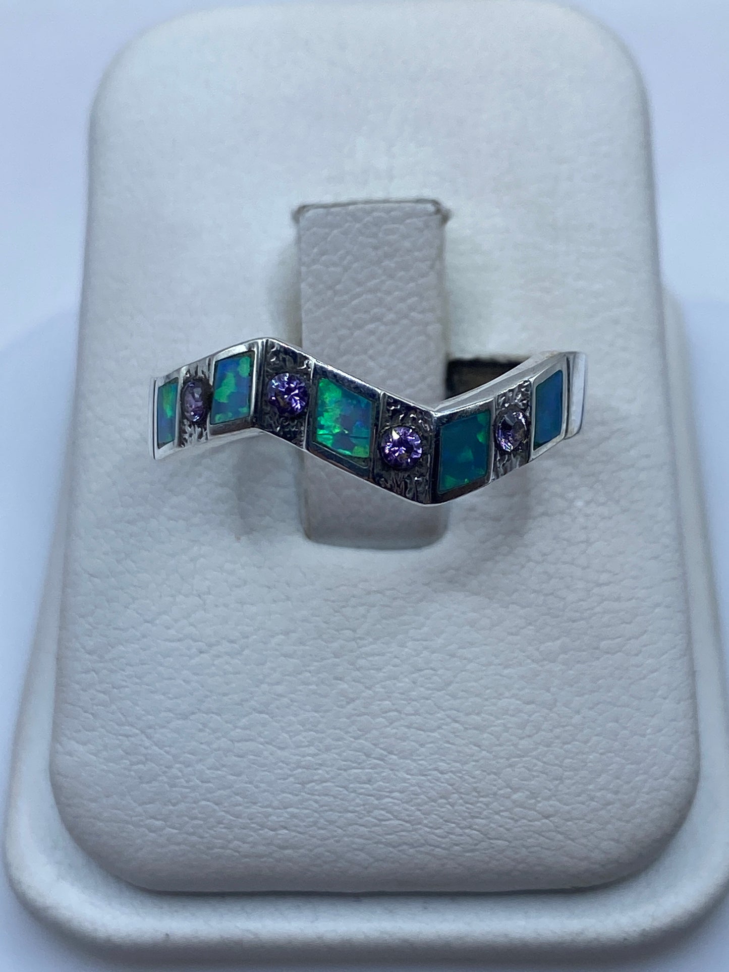 Anillo de plata ondulante con Ópalo de Fuego verde y azul en mano de mujer