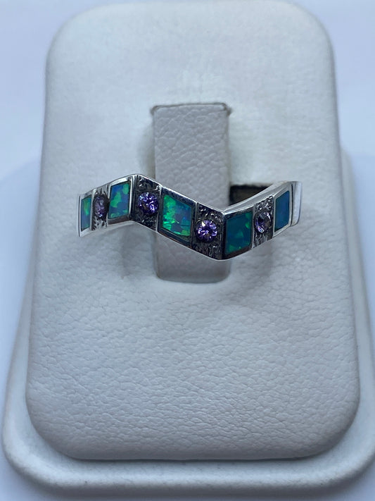 Anillo de plata ondulante con Ópalo de Fuego verde y azul en mano de mujer