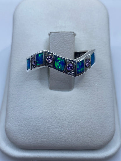 Anillo de plata .950 con ópalo de fuego azul en diseño geométrico, vista frontal sobre almohadilla blanca