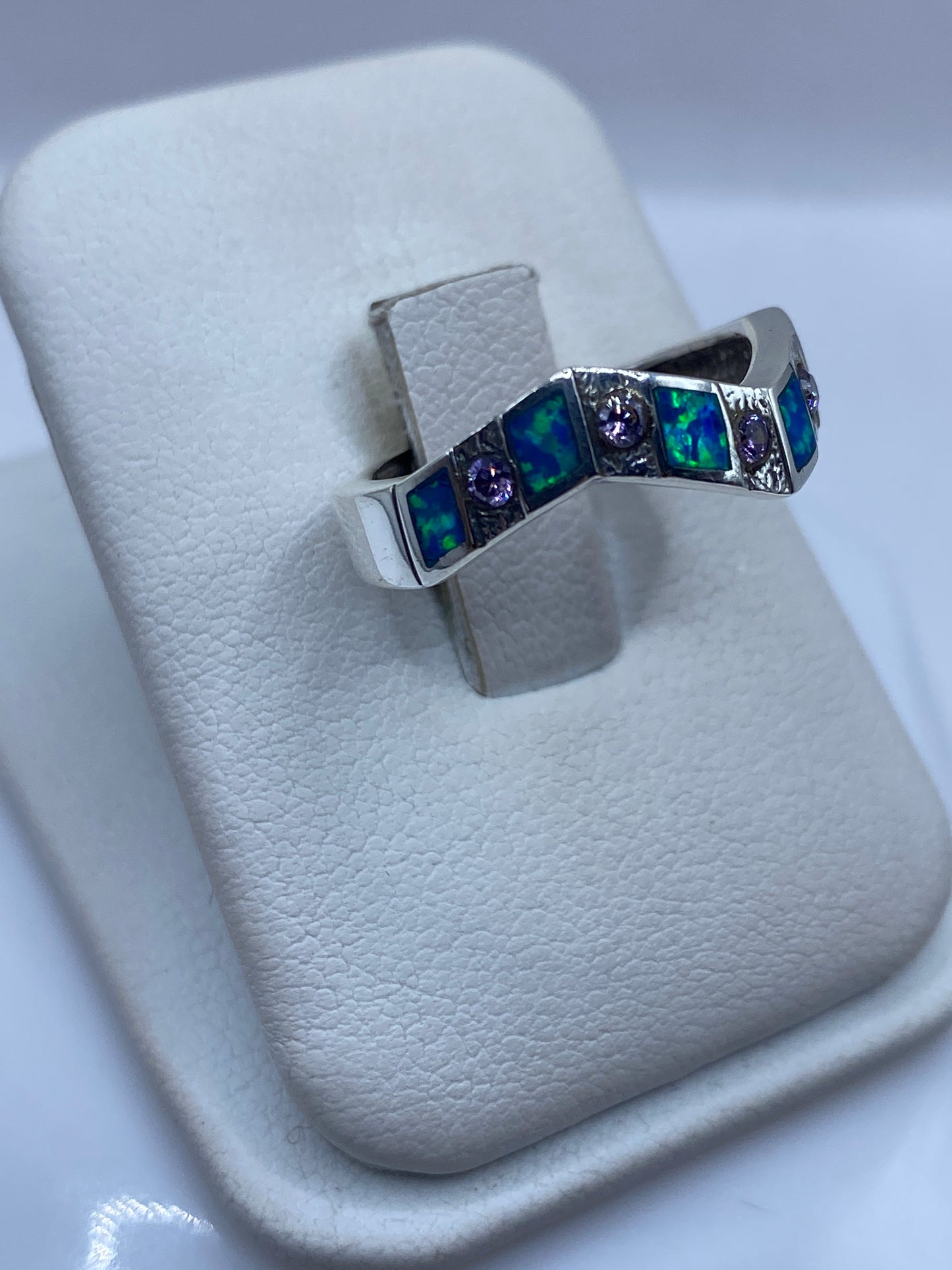 Anillo ópalo azul con franjas de plata, vista lateral mostrando el juego de colores del ópalo