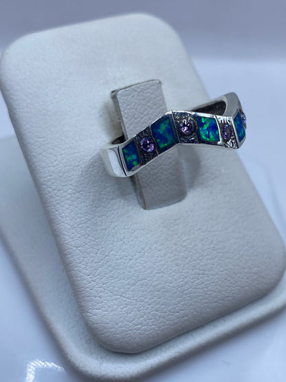 Anillo ópalo azul con franjas de plata, vista lateral mostrando el juego de colores del ópalo