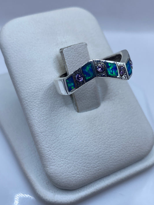 Anillo ópalo azul con franjas de plata, vista lateral mostrando el juego de colores del ópalo