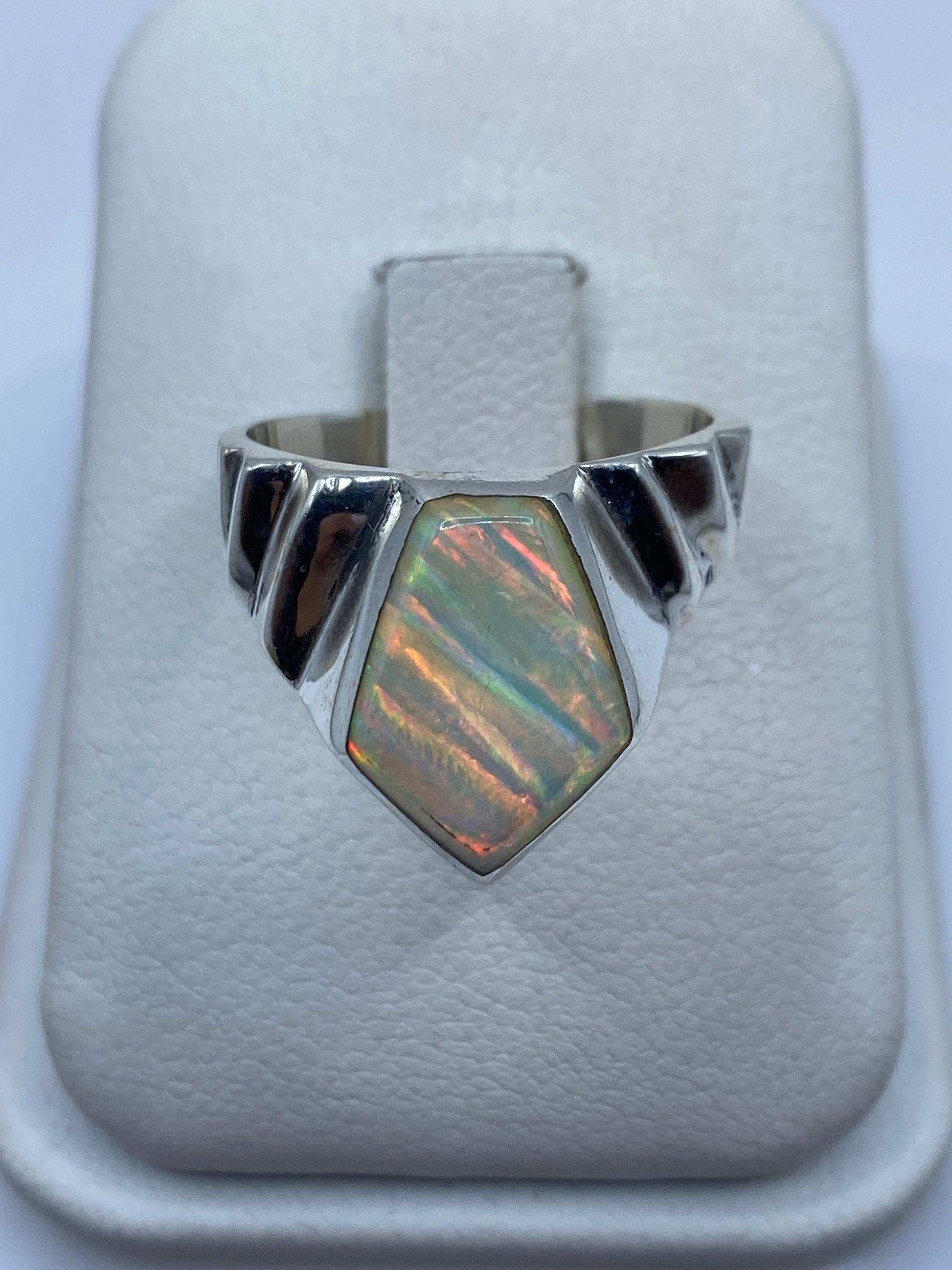Anillo de plata .950 con ópalo de fuego multicolor en frente geométrico sobre dedo anular