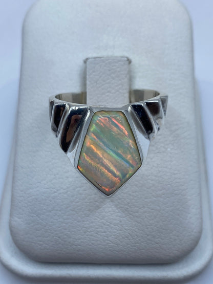 Anillo de plata .950 con ópalo de fuego multicolor en frente geométrico sobre dedo anular
