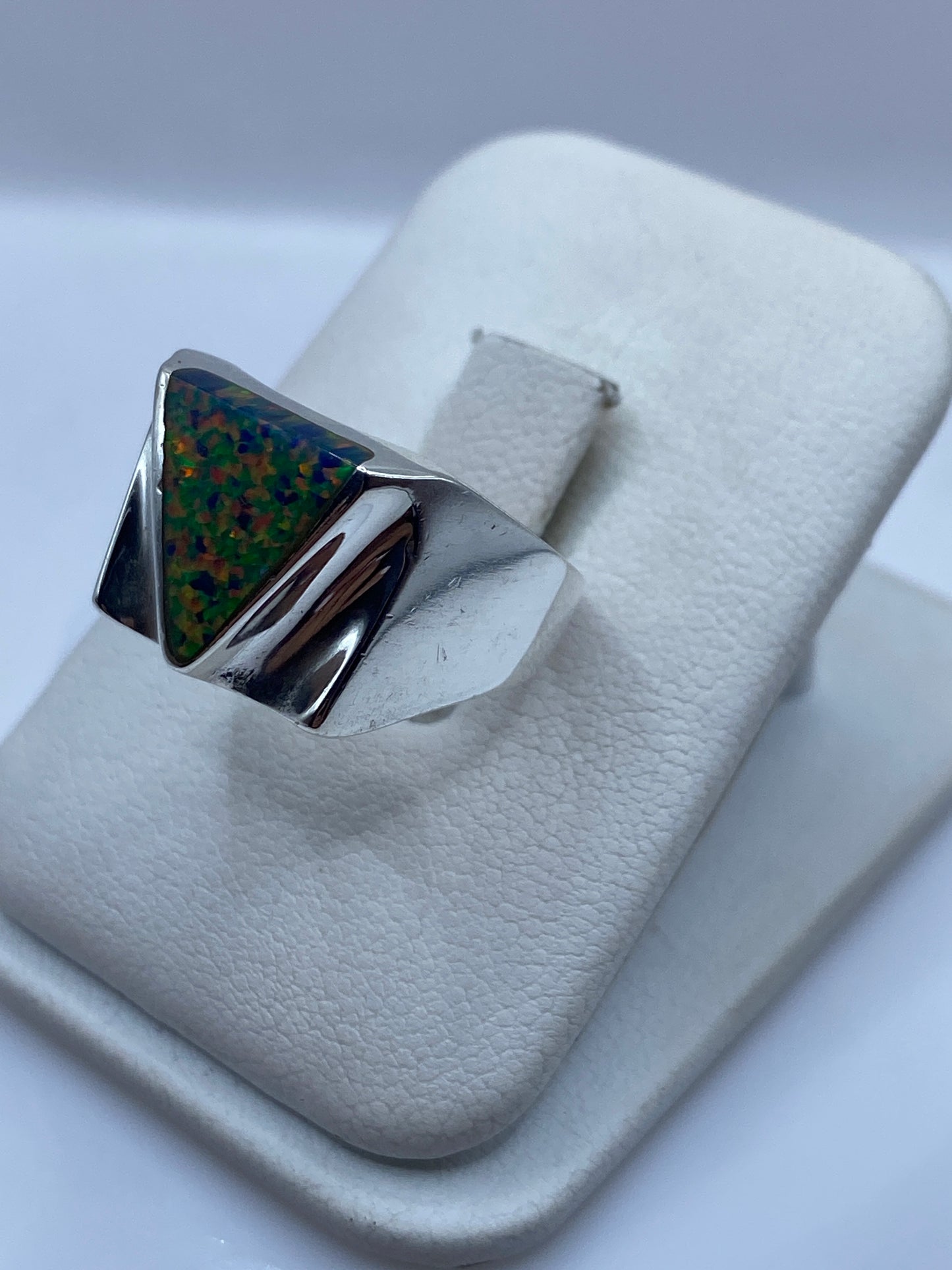 Anillo geométrico de plata .925 con ópalo de fuego en la mano de un hombre