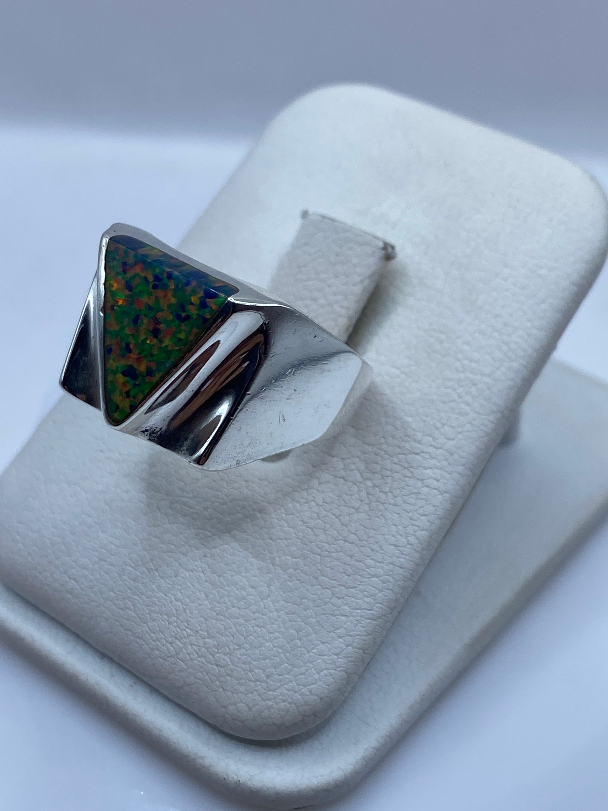 Anillo geométrico de plata .925 con ópalo de fuego en la mano de un hombre