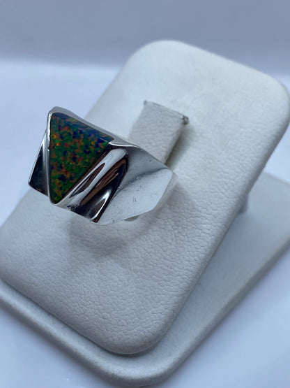 Anillo geométrico de plata .925 con ópalo de fuego en la mano de un hombre
