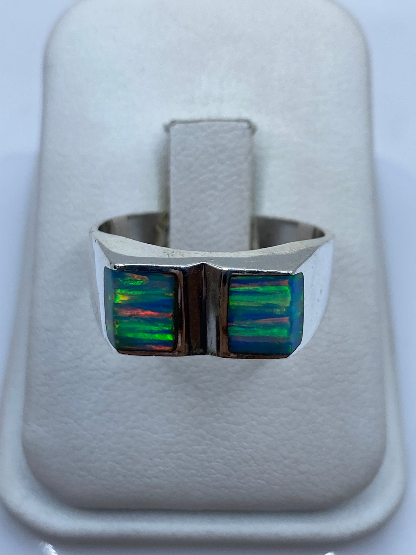 Anillo de plata .950 con ópalo de fuego azul cielo, frente amplio mostrando el juego de colores verde y naranja