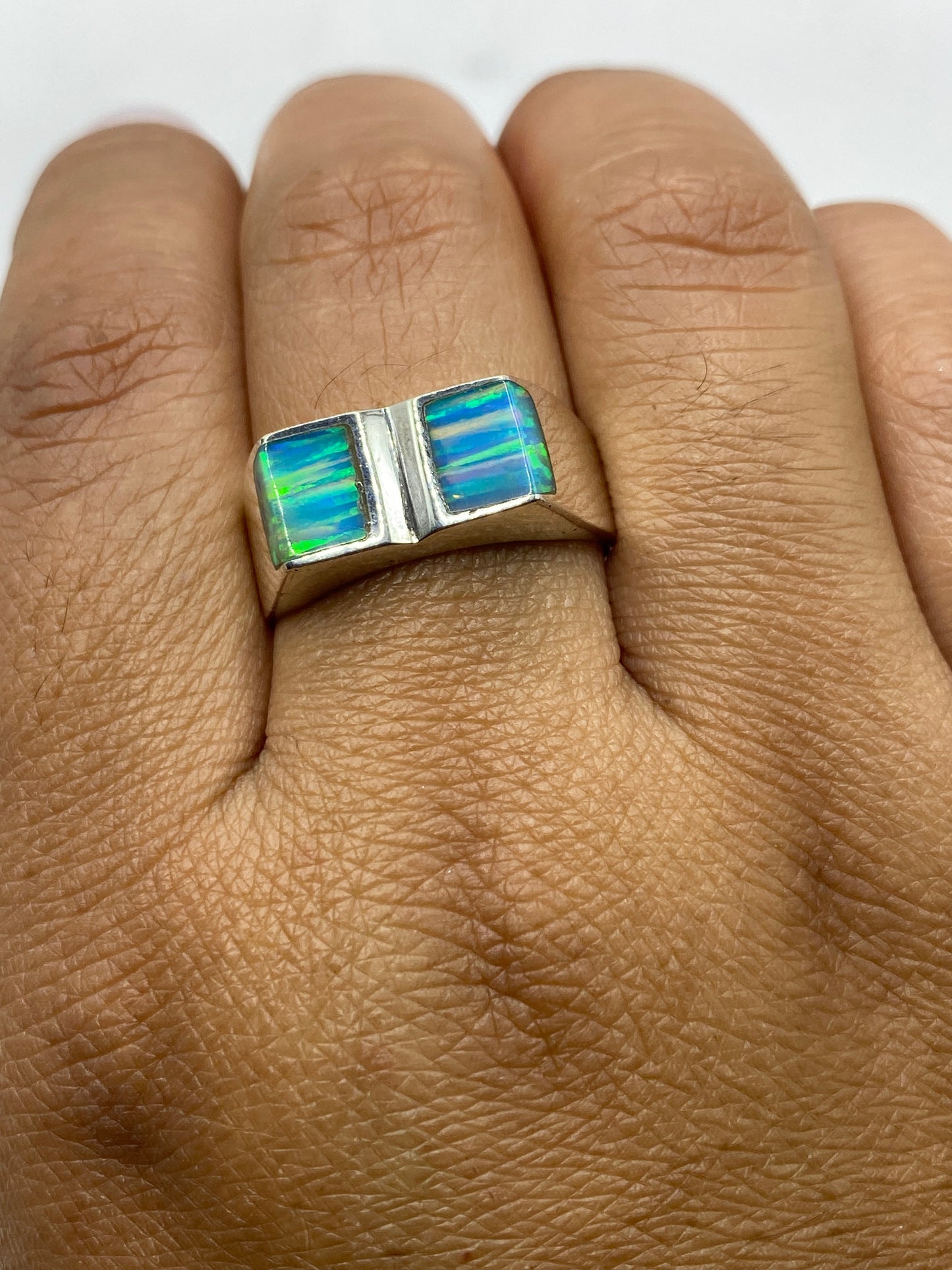 Anillo de plata .950 visto desde arriba, sello 950 visible, ópalo en su máximo brillo