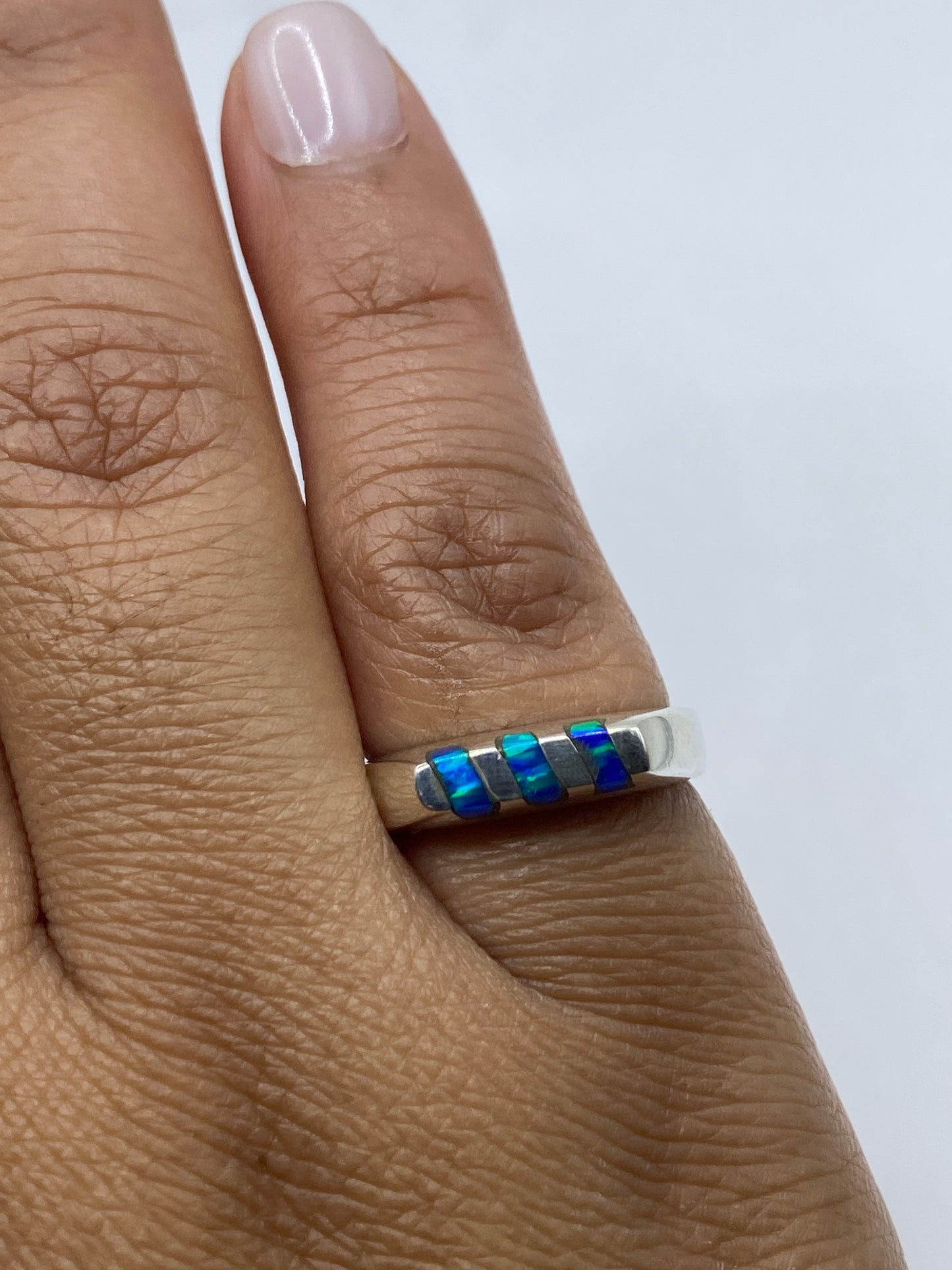 Anillo de opalo de fuego sobre fondo blanco con sello 925 visible