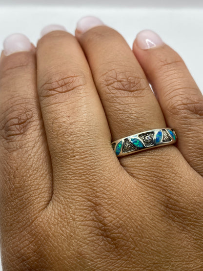 Anillo usado en dedo, ópalo azul con fuego natural visible