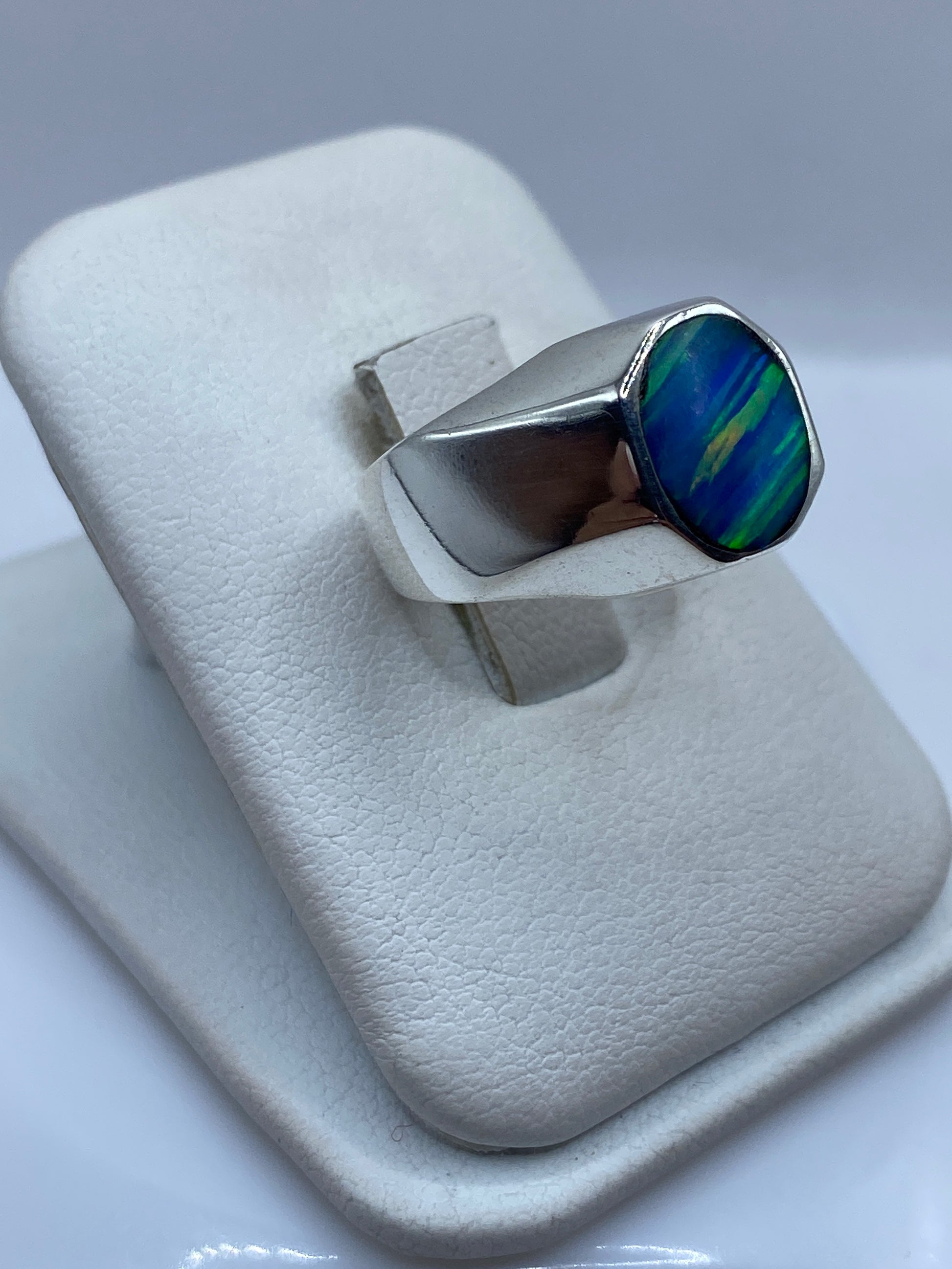 Anillo sello de plata .925 con ópalo azul visto de lado en dedo