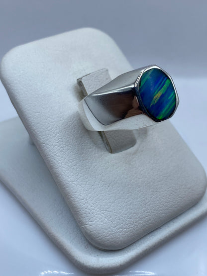 Anillo sello de plata .925 con ópalo azul visto de lado en dedo