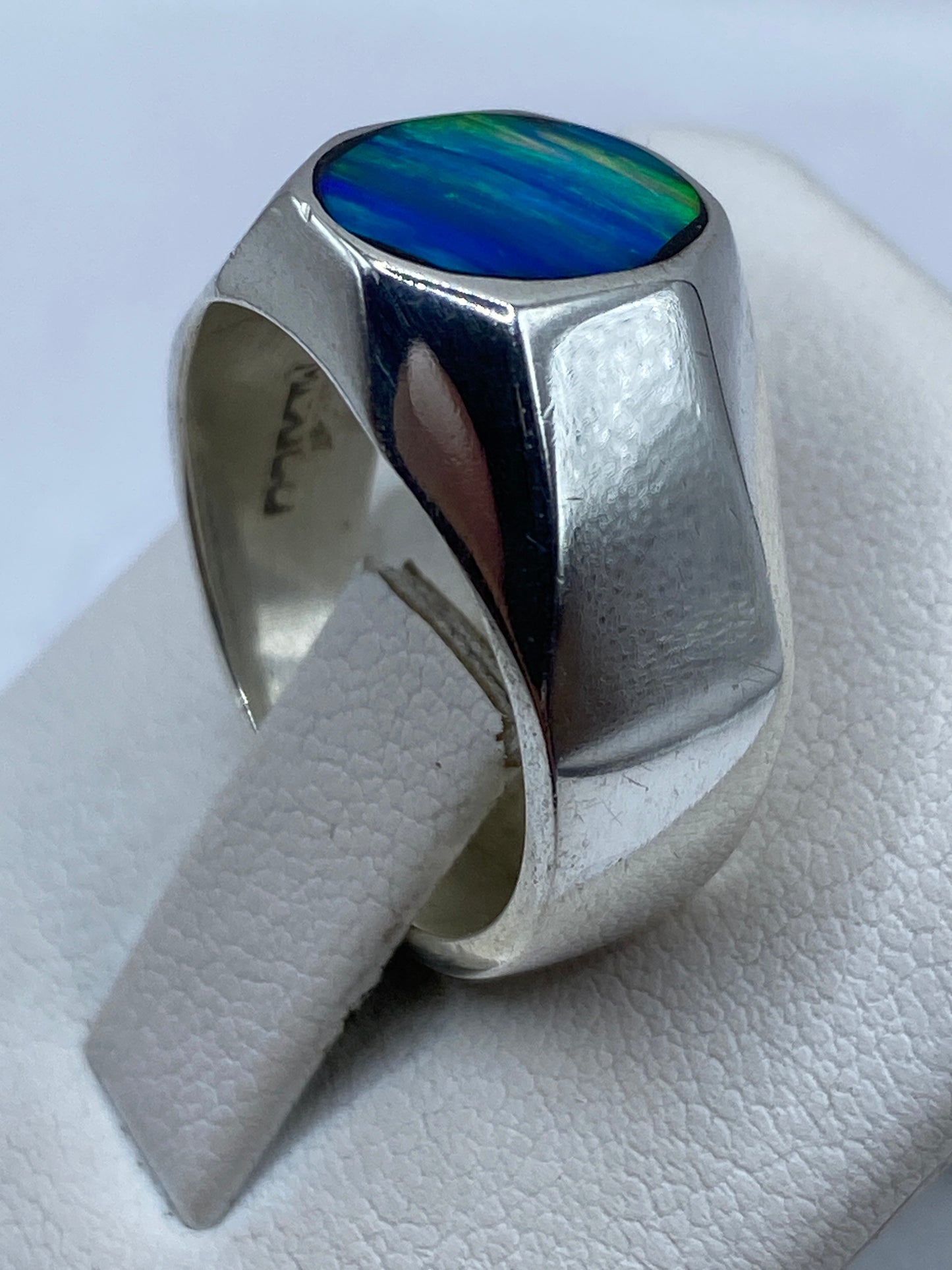 Detalle del ópalo de fuego azul en anillo sello mostrando juego de color verde