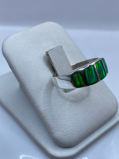 Vista frontal del anillo con ópalo de fuego mostrando reflejos verde limón y amarillo
