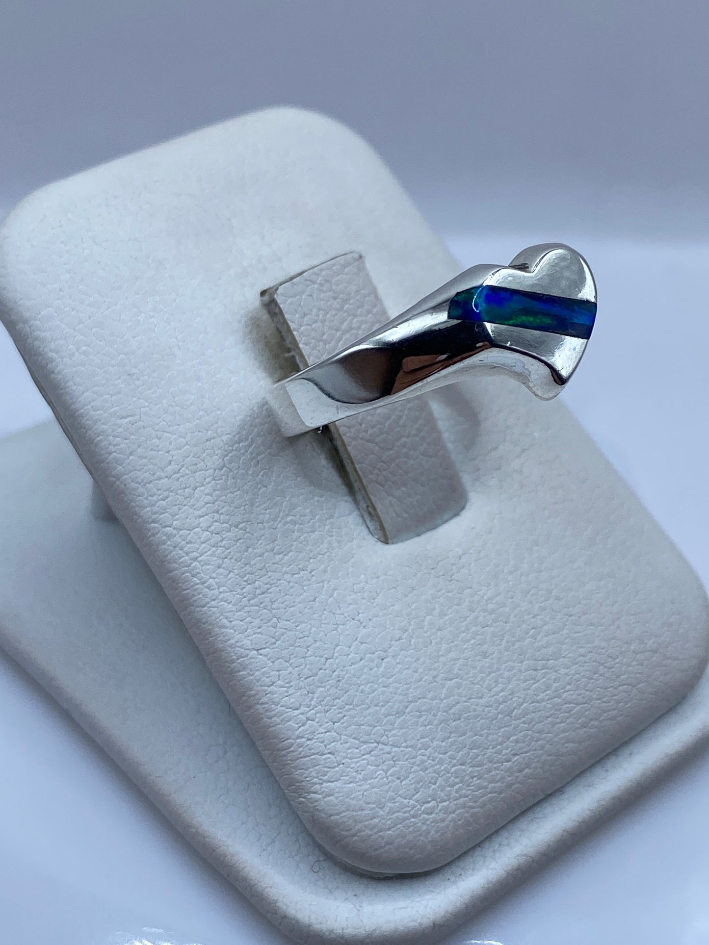 Anillo envolvente de plata mostrando el juego de colores del ópalo de fuego