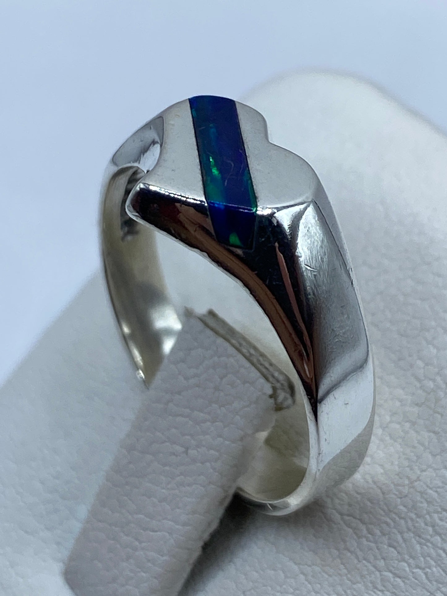 Detalle lateral del ópalo de fuego azul con vetas verdes engastado en plata